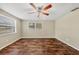 Empty living room featuring hardwood floors, ceiling fan, natural light, and neutral paint at 8470 Magnolia Dr, Seminole, FL 33777