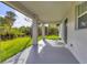Rear covered porch overlooking green landscape with beautiful palms at 102 Arrow Ln, Rotonda West, FL 33947