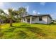 Rear exterior view of home featuring a luscious green lawn at 102 Arrow Ln, Rotonda West, FL 33947