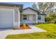 Close up of a charming single-story home with well-manicured lawn and front door at 102 Arrow Ln, Rotonda West, FL 33947