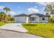 Charming single-story home featuring a two-car garage, well-manicured lawn, and welcoming curb appeal at 102 Arrow Ln, Rotonda West, FL 33947
