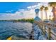Scenic waterfront view with palm trees, a clock tower gazebo, and calming blue water at 11007 Copperlefe Dr, Bradenton, FL 34212