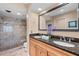 Bathroom featuring granite counters with dual sinks and a glass shower with tiled walls and floors at 1233 Dockside Pl # 207, Sarasota, FL 34242