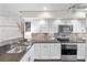 Modern kitchen featuring white cabinetry, stainless steel appliances, and stylish backsplash at 1233 Dockside Pl # 207, Sarasota, FL 34242