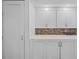 Pantry featuring white cabinets, tiled backsplash, and ample storage space at 1233 Dockside Pl # 207, Sarasota, FL 34242