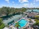 Community pool and tennis courts surrounded by lush greenery and lounging areas at 1233 Dockside Pl # 207, Sarasota, FL 34242