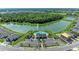 Aerial view of a community pool, clubhouse, parking and beautiful landscaping surrounded by a serene lake at 12664 Oak Hill Way, Parrish, FL 34219