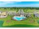 Aerial view of the community pool and clubhouse featuring beautifully landscaped surroundings and a tranquil lake at 12664 Oak Hill Way, Parrish, FL 34219