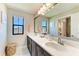 Bright bathroom with double vanity, large mirror, natural light, and view to the outside at 12664 Oak Hill Way, Parrish, FL 34219