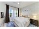 Comfortable bedroom featuring a queen bed, natural light, and stylish decor with a blue accent rug at 12664 Oak Hill Way, Parrish, FL 34219
