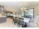 Bright dining area with a large dining table that flows into a spacious kitchen and view to the outside at 12664 Oak Hill Way, Parrish, FL 34219