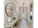 Bright entryway featuring a console table with decorative vases, a round mirror, and pendant lighting at 12664 Oak Hill Way, Parrish, FL 34219