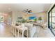 Open-concept living room with stylish sofas, neutral decor, a ceiling fan, and sliding glass doors to the backyard at 12664 Oak Hill Way, Parrish, FL 34219