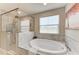Beautiful bathroom features a soaking tub, glass enclosed shower and natural light at 12664 Oak Hill Way, Parrish, FL 34219