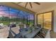 Covered outdoor patio complete with dining table, seating, string lights, and a tranquil lake view at 12664 Oak Hill Way, Parrish, FL 34219