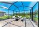 Relaxing screened patio with a fire pit, comfortable seating, and picturesque water views at 12664 Oak Hill Way, Parrish, FL 34219