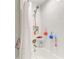 White tiled shower with a handheld shower head and curtain, a small storage space, and shower accessories at 12664 Oak Hill Way, Parrish, FL 34219