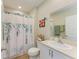 Well-lit bathroom with shower and tub combination with a white shower curtain and single sink vanity at 12738 Hysmith Loop, Parrish, FL 34219