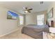 Neutral bedroom with a ceiling fan, carpet, curtains, and TV mounted on the wall above the bed at 12738 Hysmith Loop, Parrish, FL 34219