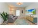 Cozy living room with hardwood floors, comfortable seating, a TV, and a cabinet at 12738 Hysmith Loop, Parrish, FL 34219