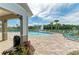 Resort-style pool area with sun loungers, a pergola, and a view of the lake, perfect for relaxation and recreation at 12738 Hysmith Loop, Parrish, FL 34219