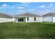 Backyard featuring a lush green lawn and a modern house with sliding glass doors at 1596 Laurel Brook Ln, Port Charlotte, FL 33953