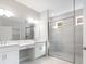 Bright bathroom featuring a double vanity, tile flooring, and a glass-enclosed shower with tiled walls at 1596 Laurel Brook Ln, Port Charlotte, FL 33953