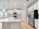 Modern kitchen with white cabinets, stainless steel appliances, and a center island with quartz countertops at 1596 Laurel Brook Ln, Port Charlotte, FL 33953