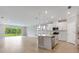 Bright kitchen with a center island, stainless steel appliances, and a view of the backyard through large sliding glass doors at 1596 Laurel Brook Ln, Port Charlotte, FL 33953