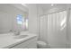 Bright bathroom featuring white cabinets, sink, toilet and tub with shower curtain at 16226 Paynes Mill Dr, Bradenton, FL 34211