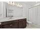 Bathroom featuring wooden cabinets, granite countertop, large mirror, and shower at 16226 Paynes Mill Dr, Bradenton, FL 34211
