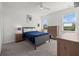 Bright bedroom features a ceiling fan, large windows and comfortable bed with blue bedding at 16226 Paynes Mill Dr, Bradenton, FL 34211