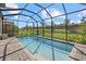 Backyard pool area featuring a screened-in pool, beautiful landscaping and view at 16226 Paynes Mill Dr, Bradenton, FL 34211