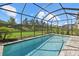 Screened-in pool features beautiful landscaping, fenced yard and clear blue skies at 16226 Paynes Mill Dr, Bradenton, FL 34211