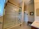 Bright bathroom featuring a bathtub with shower behind sliding glass doors and tiled walls at 193 Montelluna Dr, North Venice, FL 34275