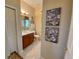 Bathroom with a single vanity, tile floors, and decorative artwork at 193 Montelluna Dr, North Venice, FL 34275