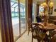 Dining room with a table for six and a view through sliding glass doors to the pool area at 193 Montelluna Dr, North Venice, FL 34275