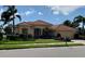 Beautiful single-story home with a red tile roof, lush landscaping, and an attached two-car garage at 193 Montelluna Dr, North Venice, FL 34275