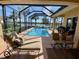 Outdoor screened-in pool with patio, lounge chairs, and views of the surrounding landscaping and lake at 193 Montelluna Dr, North Venice, FL 34275