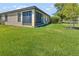 Spacious backyard featuring a screened lanai and verdant lawn at 2064 Batello Dr, Venice, FL 34292