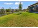 Lush backyard with a serene pond view, offering a peaceful and private outdoor space at 2064 Batello Dr, Venice, FL 34292