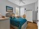 Cozy bedroom with neutral paint, wood-look floors, plantation shutters, and ceiling fan at 2064 Batello Dr, Venice, FL 34292