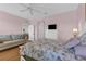 Comfortable bedroom featuring floral bedding, a plush sofa, and a ceiling fan for added comfort at 2064 Batello Dr, Venice, FL 34292