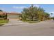 Attractive home with a manicured lawn, mature trees, and convenient access to the community gate at 2064 Batello Dr, Venice, FL 34292