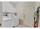 Clean laundry room featuring white cabinets, washer, and dryer, offering functionality and storage at 2064 Batello Dr, Venice, FL 34292