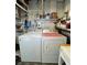 Well-lit laundry room featuring a modern washer and dryer set, complemented by convenient shelving for storage at 217 Water Oak Ln, Sarasota, FL 34237