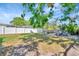Spacious backyard featuring lush greenery, a white privacy fence, patio area, and mature trees at 229 42Nd W St, Bradenton, FL 34209