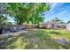 Lush green backyard with an outdoor dining set, wooden fencing, and a quaint building at 229 42Nd W St, Bradenton, FL 34209