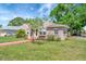 Charming single-story home with a stucco exterior, mature trees, and a well-manicured lawn at 229 42Nd W St, Bradenton, FL 34209