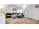 Bright living room featuring a gray sectional sofa, a ceiling mounted air conditioner, carpet flooring and a white front door at 229 42Nd W St, Bradenton, FL 34209